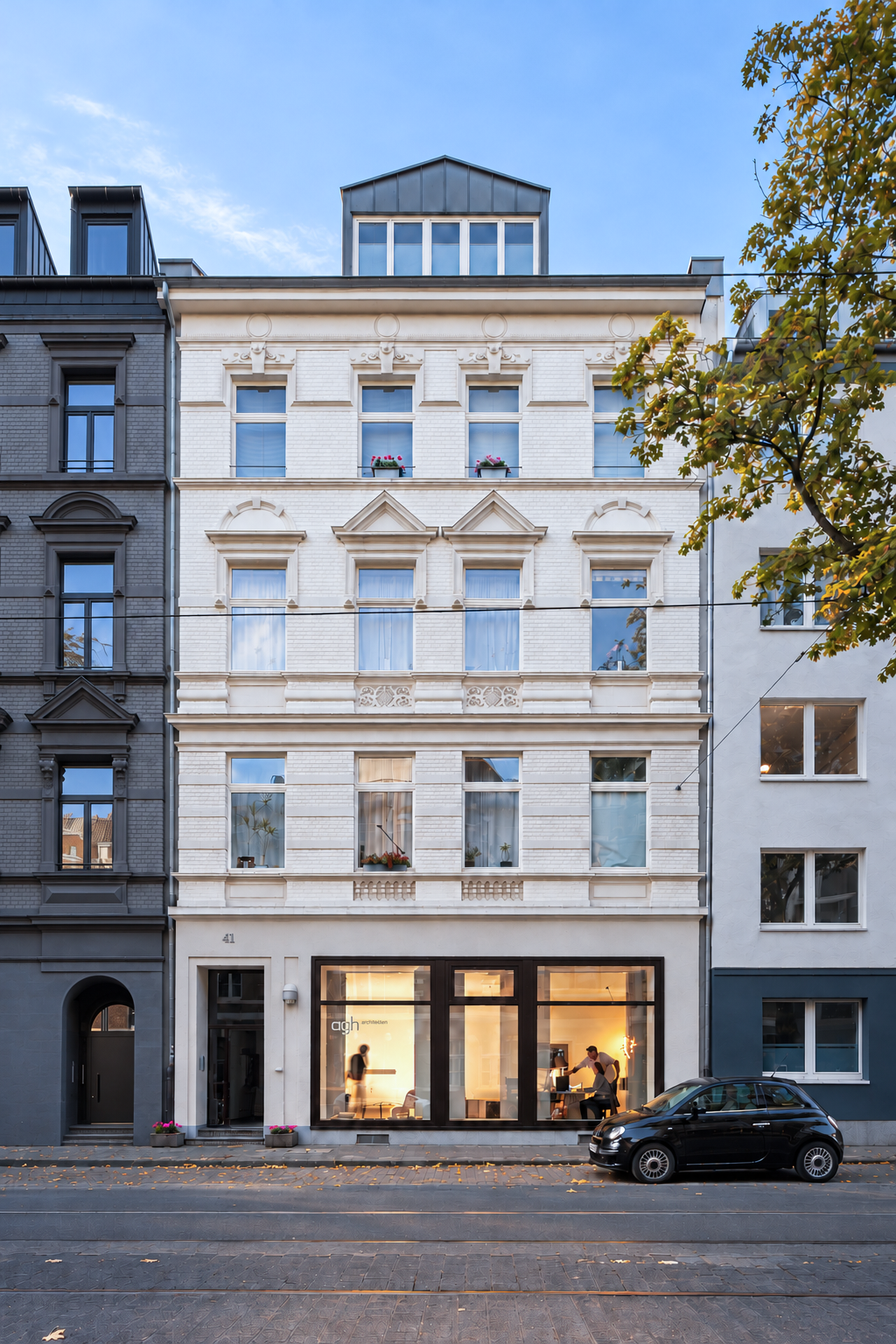 Außenansicht von agh architekten an der Blücherstraße 41 mit beleuchtetem Büro im Erdgeschoss